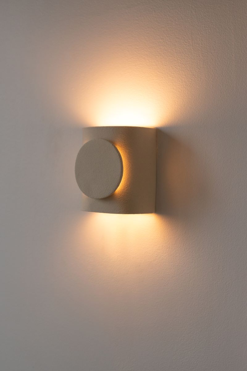 L'applique Tini Chams réalisée selon la technique de la plaque offre plusieurs sorties de lumière. Signifiant petit soleil en arabe, Tini Chams est fabriquée avec du grès blanc chamotté, terre lisse à laquelle a été rajoutée de la terre cuite broyée lui donnant une texture idéale pour le modelage et un grain authentique.