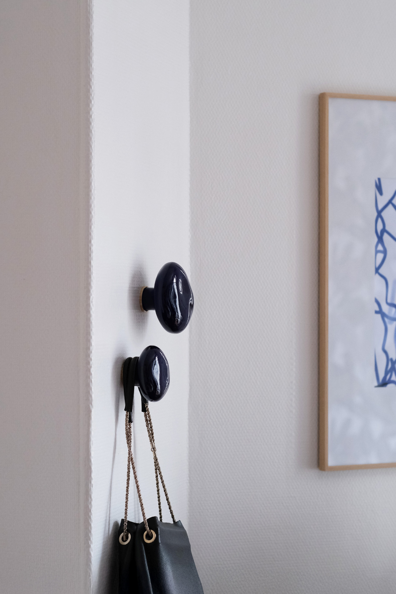 La patère Agate tire son nom de la pierre précieuse éponyme. Les Grecs et les Égyptiens l'utilisaient déjà dans la confection d'objets sacrés. Chaque patère possède sa propre personnalité, accentuée par les émaux cristallisés ou colorés qui s'harmonisent avec sa forme douce et organique, reflétant la diversité des teintes présentes dans les pierres d'Agate.

Son design intemporel et organique évoque la beauté et la simplicité des galets, tandis que sa délicate base est ornée d'une bague en laiton brossé