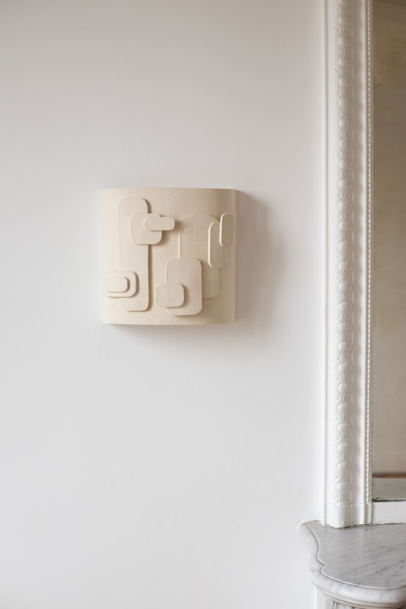 L'applique Cactus, inspirée des esquisses de la créatrice Adeline Delesalle, joue sur des formes en relief reprenant des représentations abstraites de cactus. Alliant sa profondeur à un jeu d'ombre et de lumière, l'applique est fabriquée avec du grès blanc chamotté, terre lisse à laquelle a été rajoutée de la terre cuite broyée, lui donnant une texture idéale pour le modelage et un grain authentique.