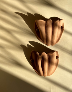 L'artiste Thalia Dalecky aime expérimenter et découvrir de nouveaux matériaux lui permettant de créer de nouvelles méthodes de création. pour cette paire d'appliques Florales en grès beige orangé, elle s'inspire de la faune et la flore couplées à ses expérimentations avec l'argile.