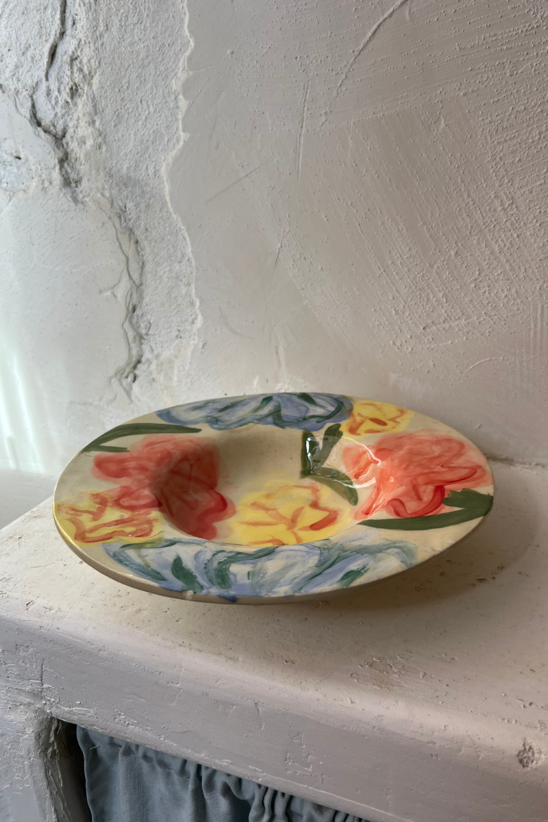 Ces assiettes Florales naissent au tour de potier, puis prennent vie sous les pinceaux de l’atelier marseillais de L’Irrégulière Céramique. Sur chaque pièce, un jardin spontané se déploie : fleurs abstraites, pétales vibrants, couleurs qui s’entremêlent et jouent avec la matière brute.