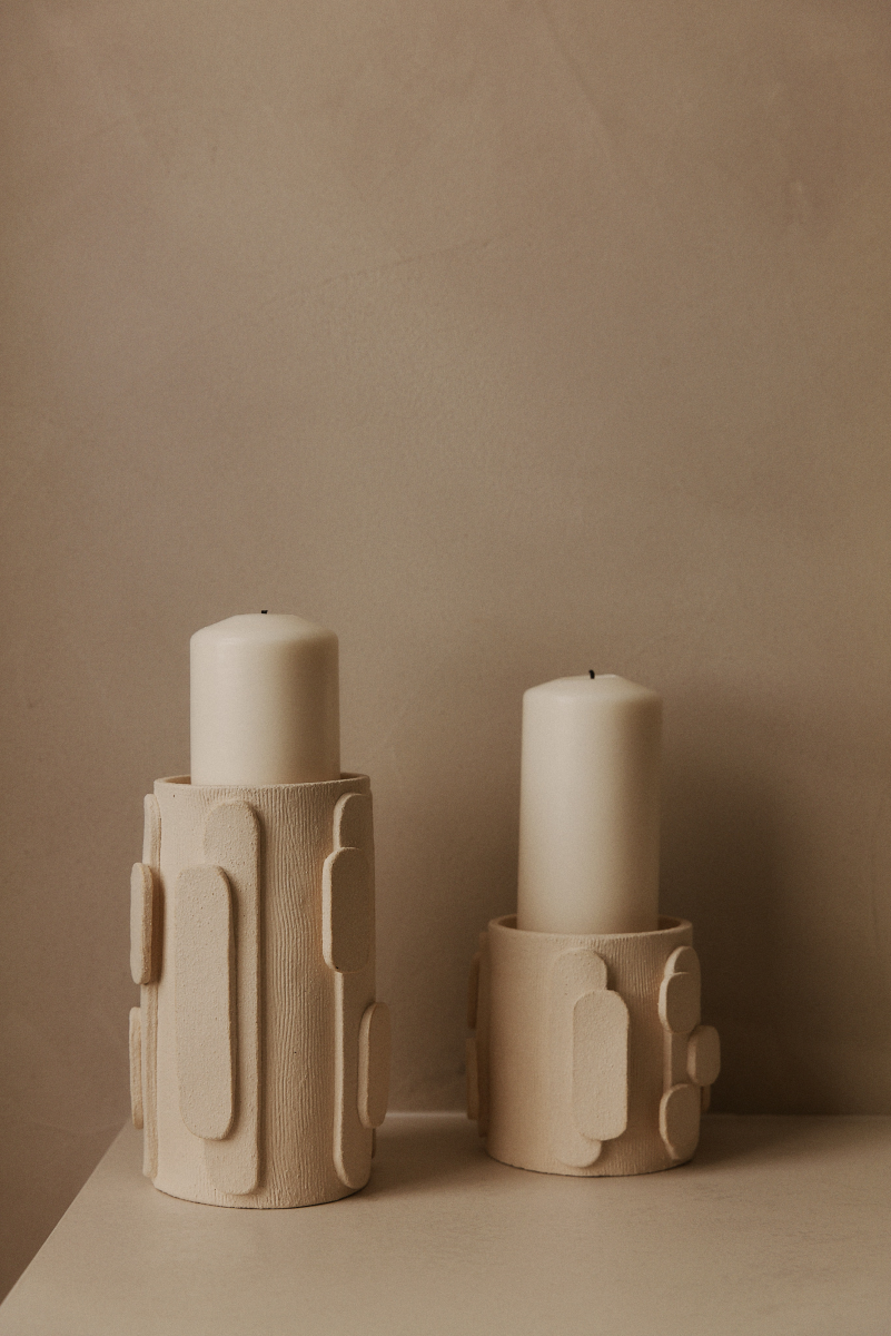 Le bougeoir Glow en exclusivité chez Caroline Andréoni La Maison tire son nom de l'éclat qu'il apporte, en anglais, évoquant ainsi la luminosité naturelle qui inspire infatigablement la créatrice Adeline Delesalle. Ce vase en moyen modèle est réalisé selon la technique de la plaque, résultat du savoir-faire de l'artiste, entièrement réalisé à la main dans ses ateliers en France. Les cylindres sont "griffés" afin de créer un contraste de matière entre le support et les éléments ajoutés.