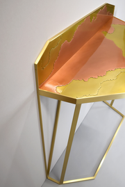 Entièrement réalisée en cuivre et laiton, la console Erosion fait un parallèle intéressant avec la transformation de l'écorce terrestre au fil du temps. Cette pièce réalisée par l'Atelier Demichelis porte ainsi son nom de cette usure que nous retrouvons sur le contraste entre les deux couleurs.  Proposé par Caroline Andréoni La Maison cette console incarne l'élégance et le raffinement.