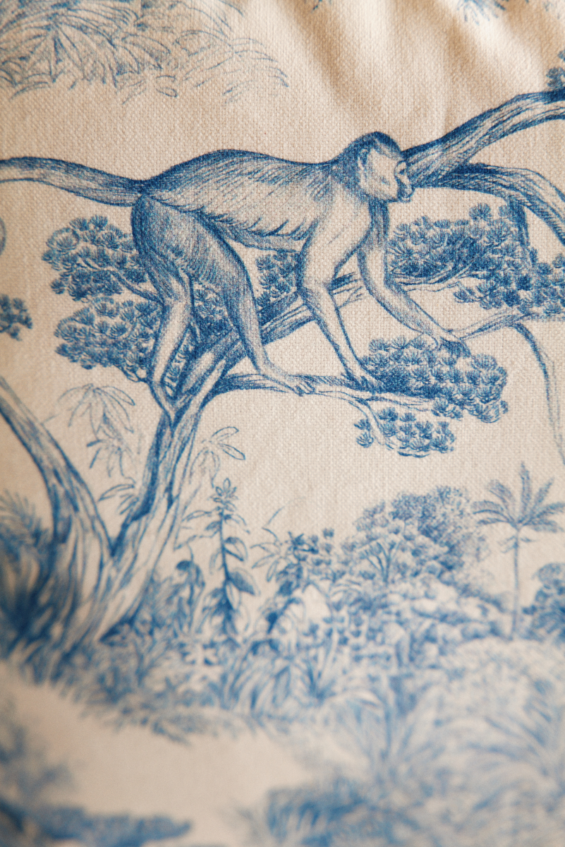 Proposé en exclusivité pour Caroline Andréoni La Maison, le coussin Animalia séduit par son motif toile de Jouy revisité dans une version moderne et audacieuse. Les nuances de bleu mettent en scène une forêt tropicale, où chaque détail illustre la finesse et l'originalité de cette pièce.

Proposée par Maison Mona, Animalia est agrémenté d'une frange bleu pétrole, apportant un subtil contraste de textures.