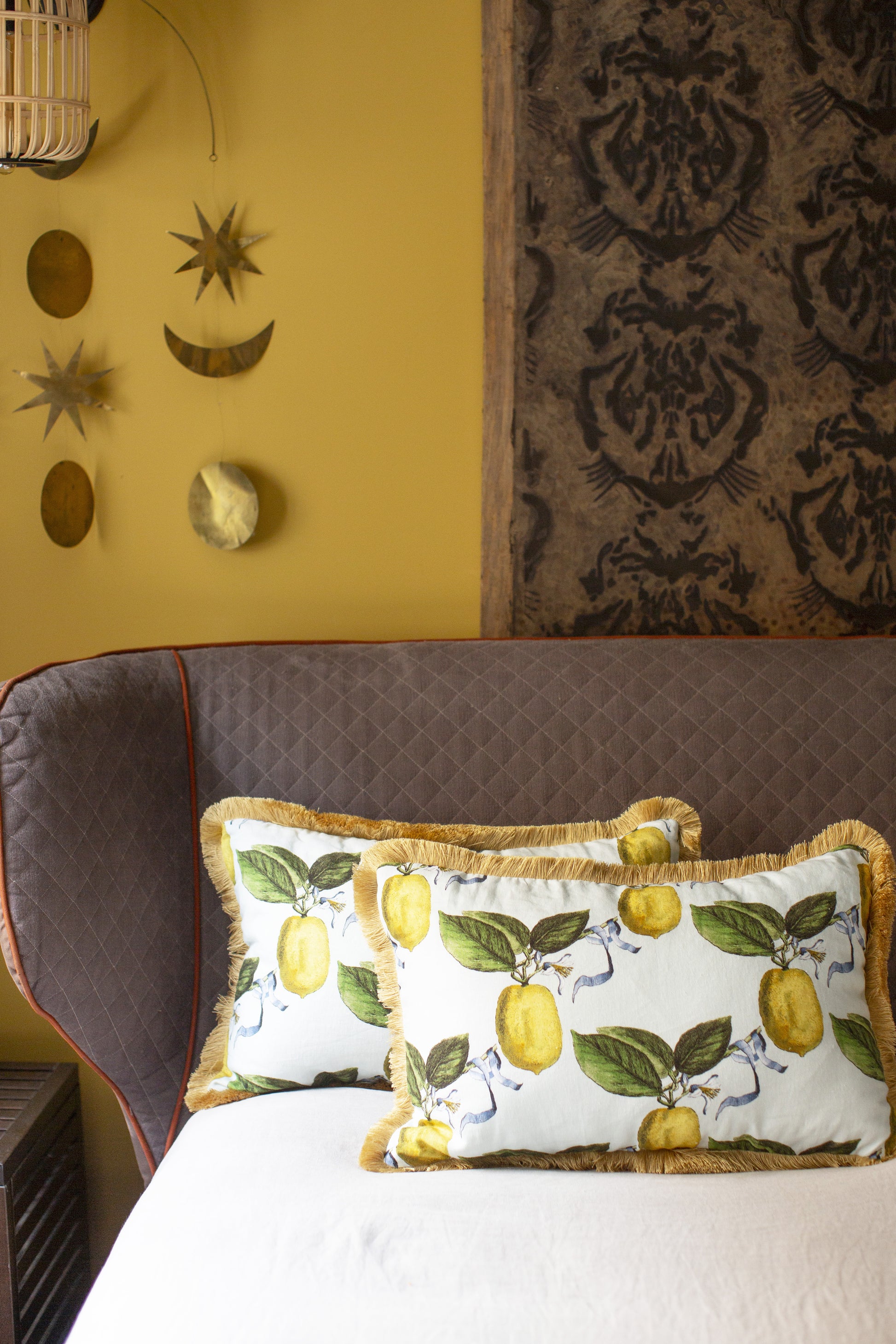 Ce coussin s’impose comme une pièce de caractère au sein de la collection Caroline Andreoni La Maison. Son imprimé citrus, à la fois lumineux et vitaminé, évoque la douceur d’un jardin méditerranéen et insuffle instantanément énergie et vitalité à votre intérieur. Le passepoil doré, discret mais élégant, souligne les contours du coussin avec finesse et capte la lumière pour un effet subtilement précieux.