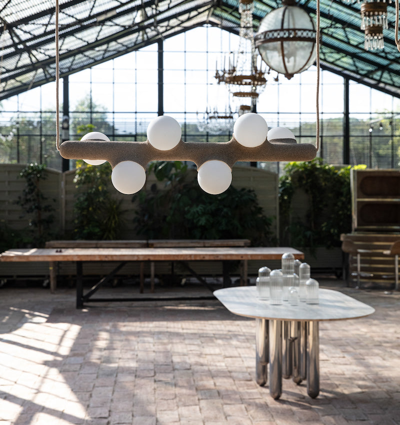 Intrigué par le figuier de barbarie qui se révèle être un outil naturel luttant contre l'érosion des sols, et participant à la préservation du territoire, Mickaël s'en inspire pour dessiner cette lampe. Volupté et douceur, sont les maîtres mots pour célébrer cette plante.  Modelée à partir de la terre que le figuier protège, l'applique Figue de Barbarie naît en terre cuite par la main du designer. Les opalines comme des baies charnues rayonnent, et mettent en lumière cette prouesse naturelle.