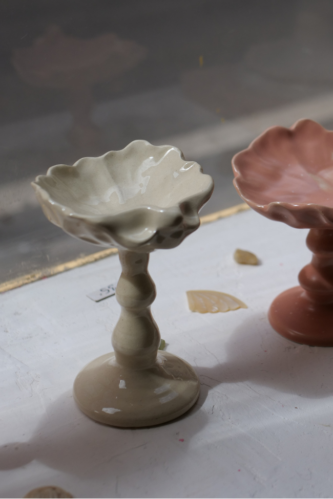 Cette coupelle sur pied, délicatement inspirée des formes de coquillage, fait partie de notre collection art de la table. Elle peut servir pour un dessert ou même comme écrin pour bijoux.

Chaque pièce est produite à la main et à la commande dans notre atelier marseillais, ce qui rend chacune singulière : de légères variations de taille, de forme ou de texture témoignent du travail artisanal.

Pour préserver sa beauté dans le temps, nous recommandons un lavage à la main.