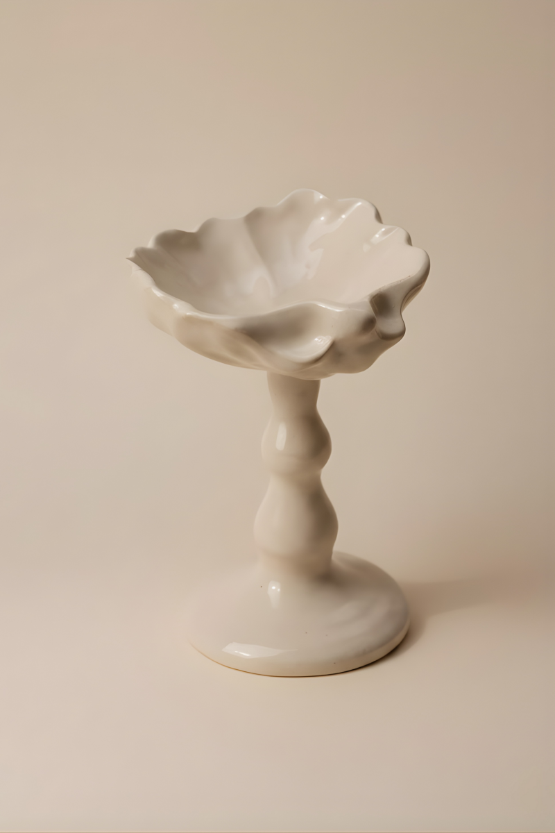 Cette coupelle sur pied, délicatement inspirée des formes de coquillage, fait partie de notre collection art de la table. Elle peut servir pour un dessert ou même comme écrin pour bijoux.

Chaque pièce est produite à la main et à la commande dans notre atelier marseillais, ce qui rend chacune singulière : de légères variations de taille, de forme ou de texture témoignent du travail artisanal.