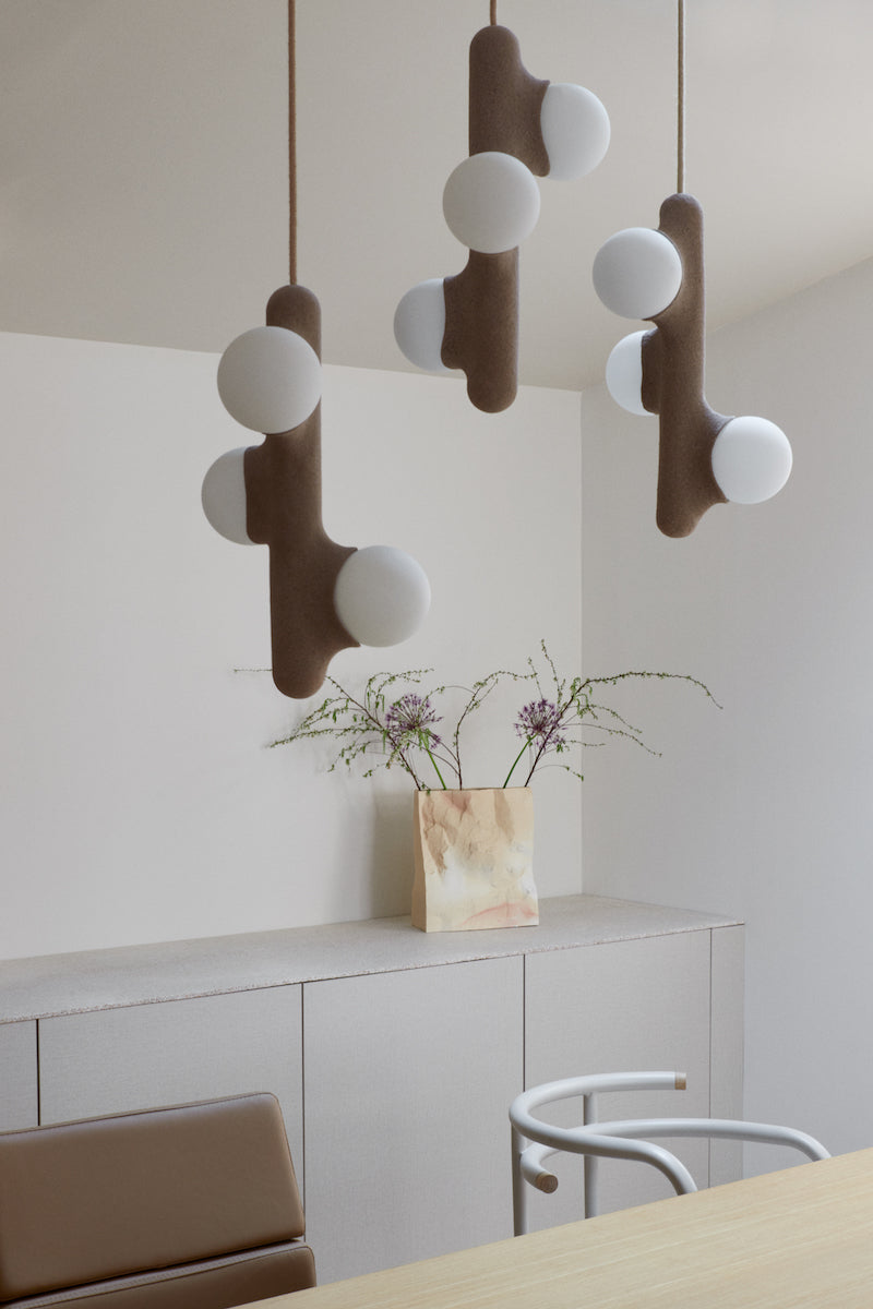 Intrigué par le figuier de barbarie qui se révèle être un outil naturel luttant contre l'érosion des sols, et participant à la préservation du territoire, Mickaël s'en inspire pour dessiner cette lampe. Volupté et douceur, sont les maîtres mots pour célébrer cette plante.  Modelée à partir de la terre que le figuier protège, l'applique Figue de Barbarie naît en terre cuite par la main du designer. Les opalines comme des baies charnues rayonnent, et mettent en lumière cette prouesse naturelle.