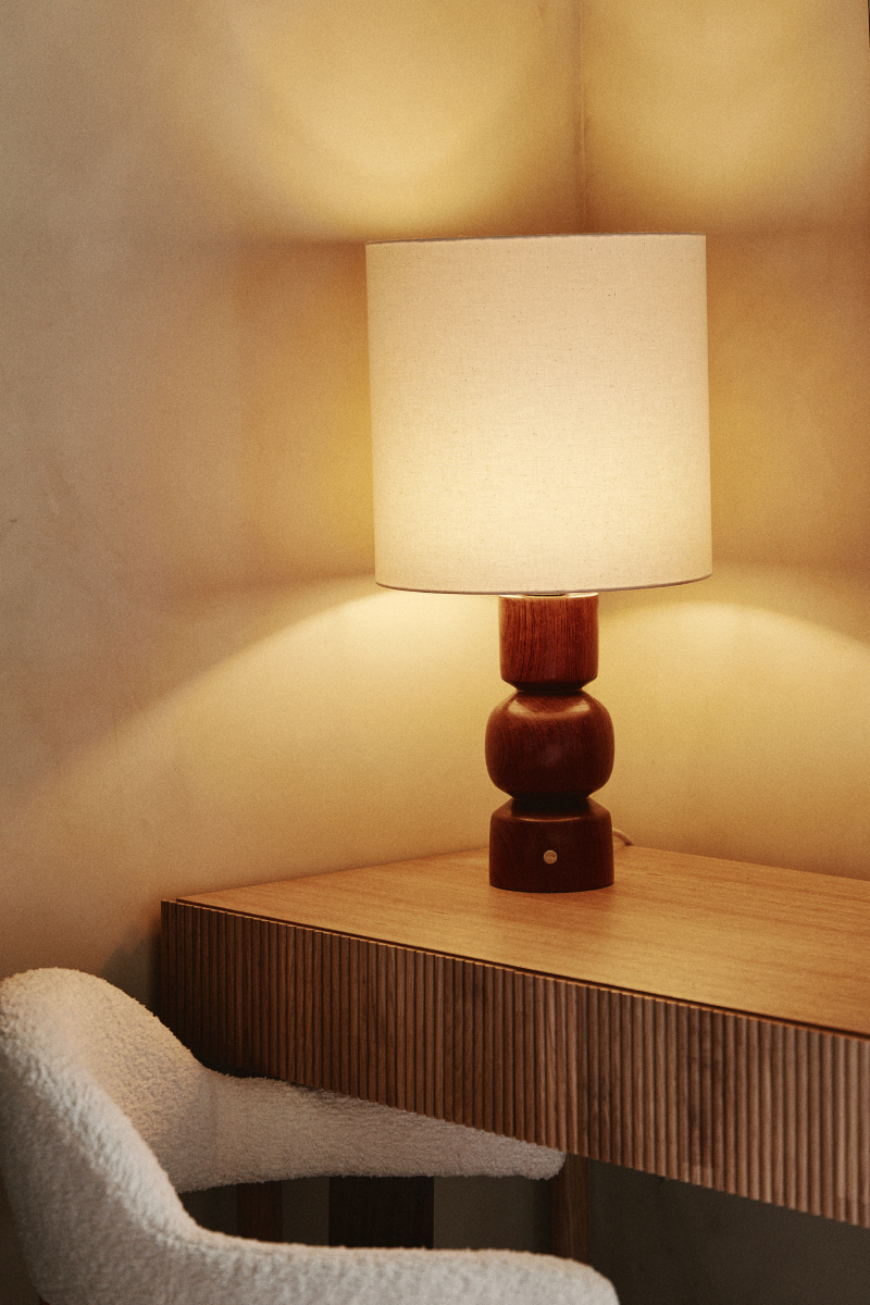 Les lignes pures, tout en rondeurs de la lampe Gilou, inspirées par les styles architecturaux des années 70, mettent en valeur le veinage zébré et profond du Wengé.&nbsp; Sa finition à la cire d'abeille apporte un rendu satiné et soyeux qui permet de préserver l'aspect naturel et authentique du bois, tout en le sublimant. L'abat jour écru permet de mettre en valeur le pied de lampe et apporte une lumière douce et diffuse.