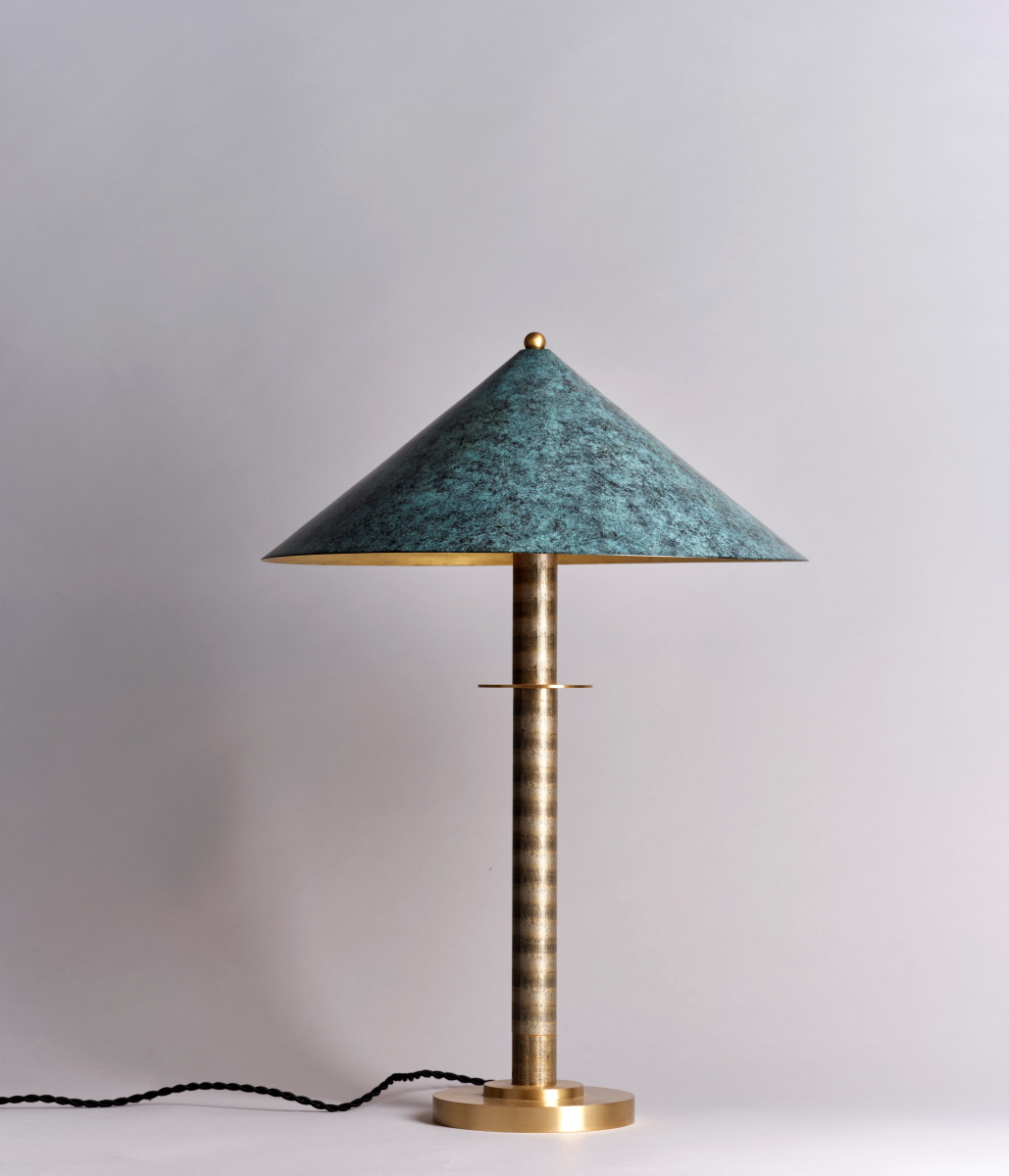 La lampe à poser Louisa incarne l'esthétique élégante et distinctive de Marine Breynaert, parfaite pour rehausser une table d'appoint dans un salon, un bureau ou une chambre. Fabriquée en laiton massif et aluminium thermolaqué, elle se distingue par son abat-jour en laiton patiné, offrant une teinte bleuâtre subtile et unique. Ce détail confère à la lumière une douceur singulière et crée une atmosphère apaisante.