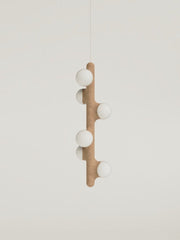 Intrigué par le figuier de barbarie qui se révèle être un outil naturel luttant contre l'érosion des sols, et participant à la préservation du territoire, Mickaël s'en inspire pour dessiner cette lampe. Volupté et douceur, sont les maîtres mots pour célébrer cette plante.  Modelée à partir de la terre que le figuier protège, l'applique Figue de Barbarie naît en terre cuite par la main du designer. Les opalines comme des baies charnues rayonnent, et mettent en lumière cette prouesse naturelle.