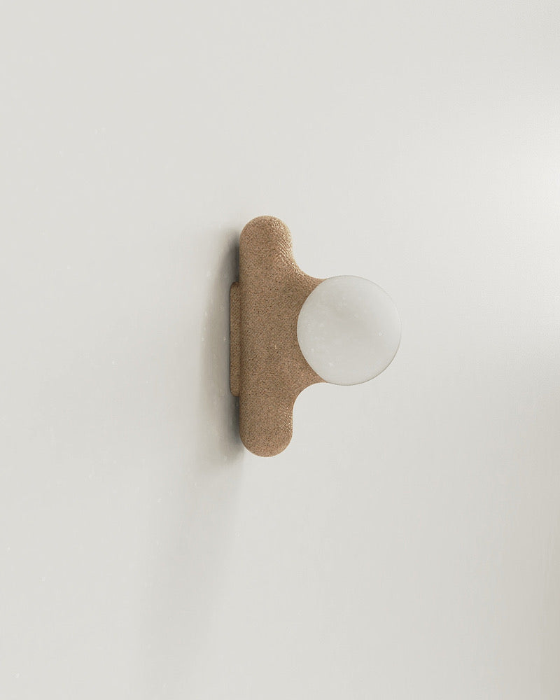 Intrigué par le figuier de barbarie qui se révèle être un outil naturel luttant contre l'érosion des sols, et participant à la préservation du territoire, Mickaël s'en inspire pour dessiner cette lampe. Volupté et douceur, sont les maîtres mots pour célébrer cette plante.  Modelée à partir de la terre que le figuier protège, l'applique Figue de Barbarie naît en terre cuite par la main du designer. Les opalines comme des baies charnues rayonnent, et mettent en lumière cette prouesse naturelle.