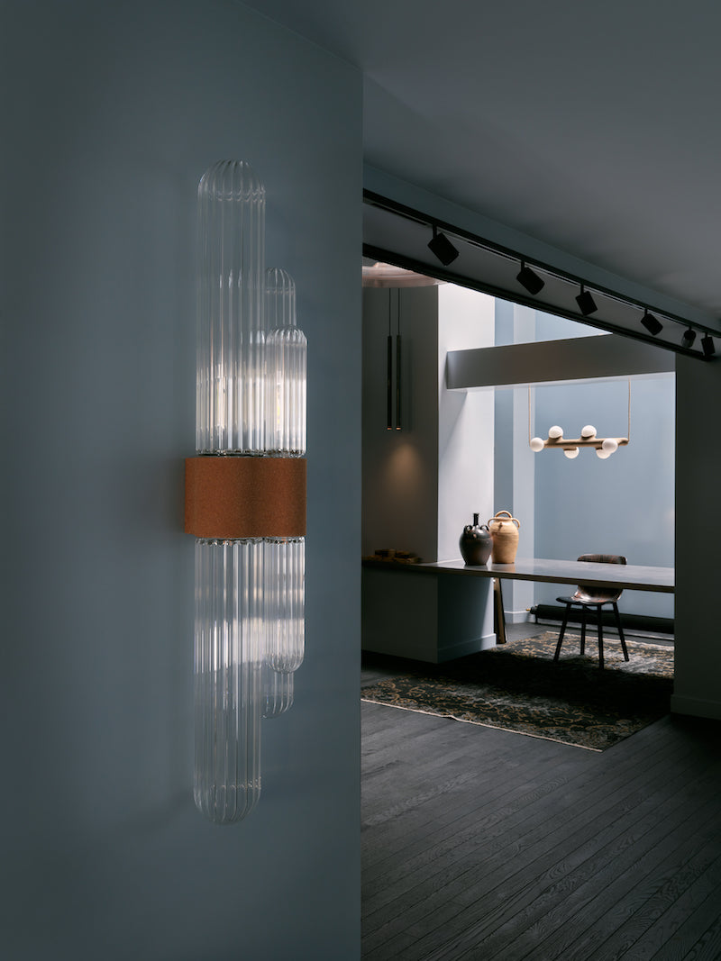 La rencontre de Mickaël avec un artisan verrier lui permet de retranscrire toutes les nuances d'oscillations et de reflets auxquels le paysage méditerranéen l'a habitué. Des cannes striées, fumées ou transparentes assemblées sous la forme d'un cactus élancé et raffiné, qui révèlent toute leur singularité en s'éclairant.  Tous les reliefs du verre sont projetés sur l'environnement qui l'entoure. Une ode au territoire d'origine de Mickaël.