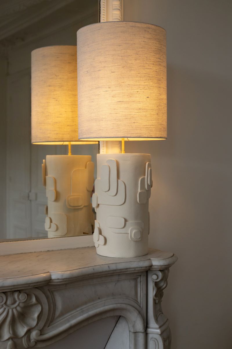 La lampe Cactus en exclusivité chez Caroline Andréoni La Maison, est directement inspirée des esquisses de la créatrice Adeline Delesalle. Cette lampe à poser joue sur des formes en relief évoquant des représentations abstraites de cactus. La profondeur du pied s'associe à un jeu subtil d'ombres et de lumières créé par l'abat-jour, confectionné à base de soie.