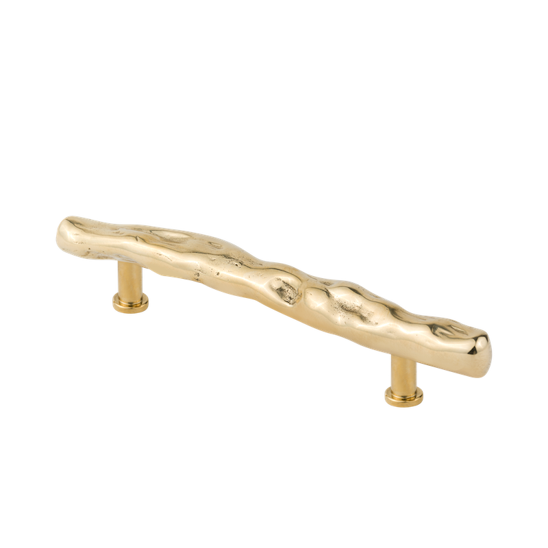 La poignée de meubles Ego en laiton est fabriquée à la main selon la technologie de moulage traditionnelle en Pologne, par des artisans expérimentés.  Inspirée de la nature, elle s'apparente à un morceau de bois qui aurait été poli par l'eau salée de la mer. Elle fait partie d'une collection de poignées aux dimensions extra-larges, idéales pour les façades de meubles hauts.