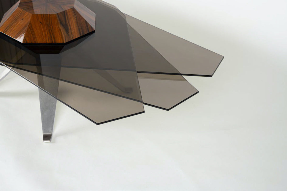 Corps céleste. Atterrissage en douceur pour ce module tabulaire inspiré par Saturne.&nbsp;De forme elliptique ou circulaire, Starsky s’adapte aux envies et habille un intérieur de façon sculpturale. Bien campée sur des pieds en inox massif et son corps en Palissandre Dos Santos, cette table modulable offre de nombreuses options grâce à ses lamelles de verre mobiles&nbsp;qui se déploient tels des panneaux solaires en fonction du nombre de convives.