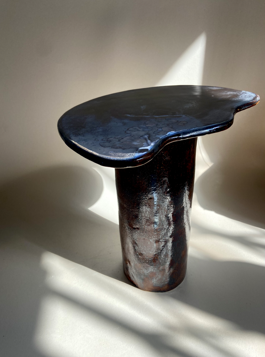 Petite table d'appoint Tempête au design épuré réalisé en céramique à effets métallisés sur le plateau et noir. Cette pièce, réalisée par l'artiste Thalia Dalecky, présente des ornages sur le pied.