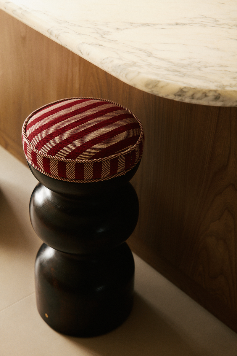 L'alliance de la forme ronde et symétrique, mêlée au motif extrêmement naturel et aléatoire du bois rend chaque création de Romie Objetti unique. Sa finition à la cire d'abeille apporte un rendu satiné et soyeux qui permet de préserver l'aspect naturel et authentique du bois, tout en le sublimant.

Proposée en exclusivité par Caroline Andréoni La Maison, le tabouret Yoko est revêtu par le tissu Voulez-vous teinte Amerana de chez Dedar.