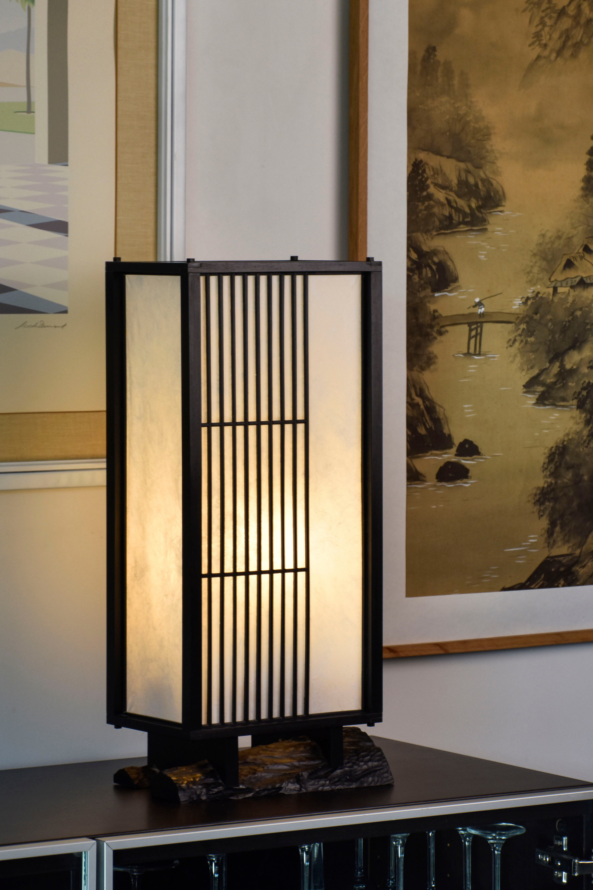 Véritable héritage de la culture japonaise traditionnelle, cette lampe puise son inspiration dans l’équilibre entre rigueur et douceur. Imaginée par le designer Thomas Coup La Fronde, elle associe la précision des savoir-faire artisanaux aux courbes organiques d’un pied en ébène massif. Les assemblages, subtilement révélés, témoignent d’une exigence rare tout en préservant une esthétique épurée et intemporelle.