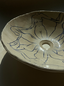 L'artiste Thalia Dalecky propose une vasque à poser "Danseuses" représentant des nus féminins dessinés à la main de couleur bleu nuit. Cette œuvre elle honore toutes les femmes qui l’entourent de près ou de loin : celles qui ont quelque chose à dire, celles qui se battent, qui se sont battues et celles qui sont en paix. Avec un diamètre entre 38 et 42 centimètres et une hauteur de 15 centimètres, cette vasque est travaillée avec du grès blanc, un émail transparent brillant et une peinture bleu océan.