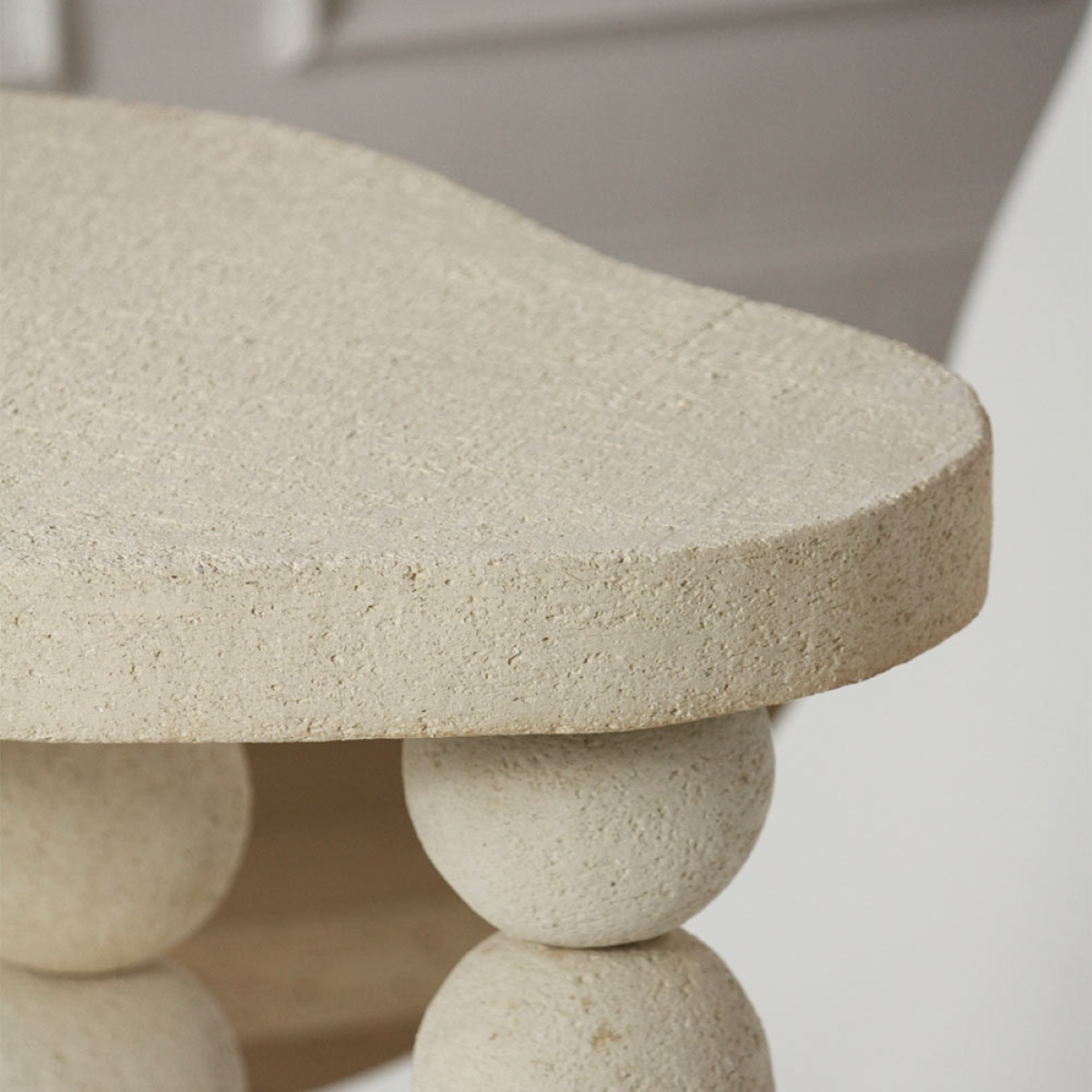 Cette table d'appoint Joia constituée de grès chamotte présente une texture avec des grains de sable.&nbsp;Chaque pièce est unique, numérotée, signée et modelée manuellement dans un grès chamotte, une argile cuite plusieurs fois entre 900 et 1400 degrés.

Grâce à la céramique, Alan Louis capture l’essence particulière de l’élégance brute et naturelle.