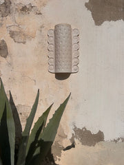 L'applique Ammon est entièrement réalisée à la main par Isabelle Carcy dans son atelier Maison Paradis en méditerranée. La mer Méditerranée, sa faune et sa flore constituent la principale source d’inspiration du travail d’Isabelle à mi-chemin entre la sculpture et la pièce décorative, Il émane une grande poésie dans son travail.

Ici, les fossiles (ammonites et petits coquillages) ont influencé le modelage de cette applique.