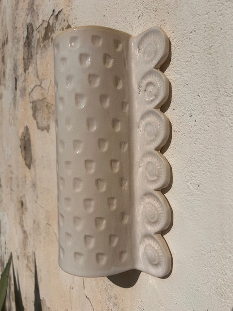 L'applique Ammon est entièrement réalisée à la main par Isabelle Carcy dans son atelier Maison Paradis en méditerranée. La mer Méditerranée, sa faune et sa flore constituent la principale source d’inspiration du travail d’Isabelle à mi-chemin entre la sculpture et la pièce décorative, Il émane une grande poésie dans son travail.

Ici, les fossiles (ammonites et petits coquillages) ont influencé le modelage de cette applique.