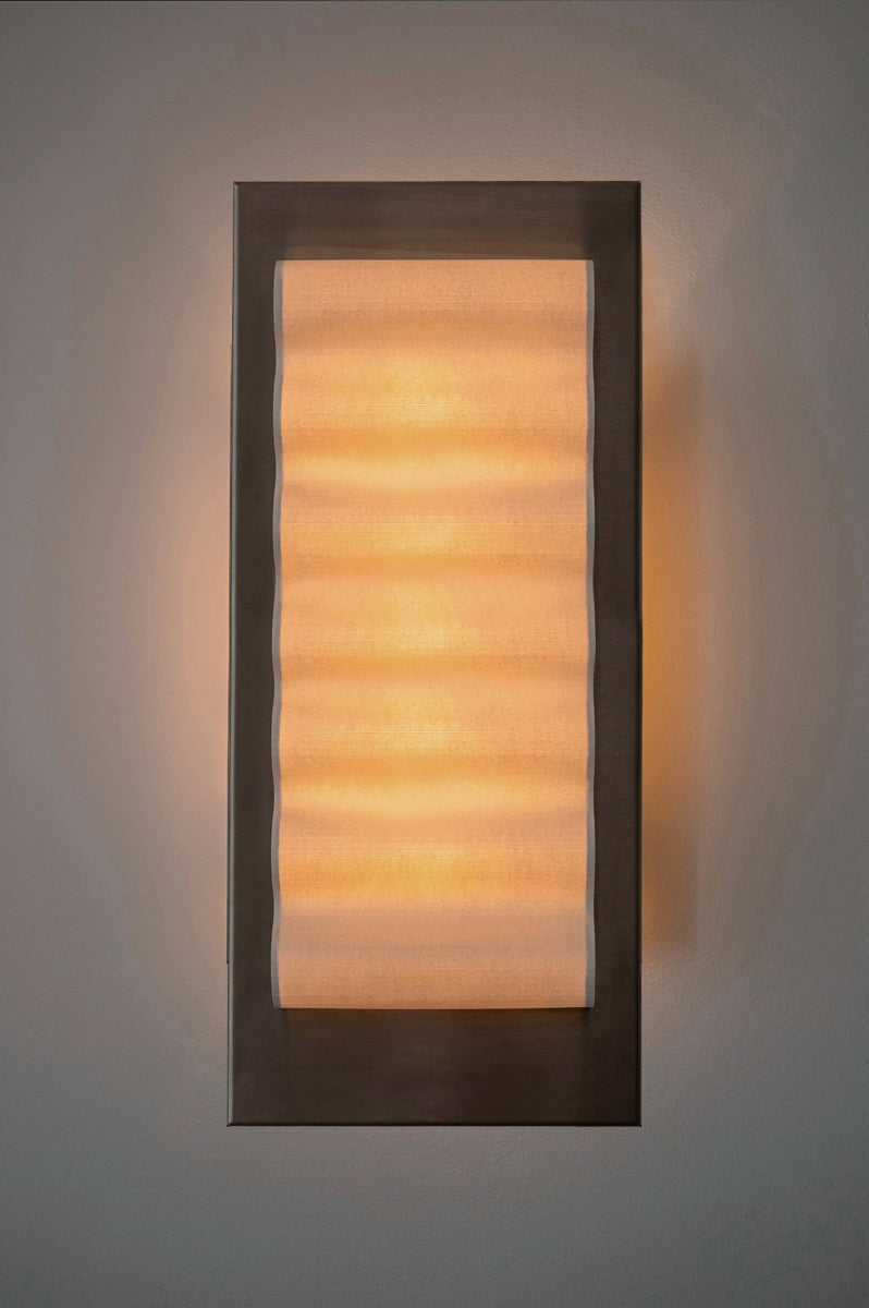 Les appliques Frame Alu Brut de Violaine d'Harcourt sont fabriquées à la main au Portugal, en aluminium et papier.

Dotées d'un design minimaliste et rendant un subtil hommage à l'architecture moderne, les appliques murales Frame sont réalisées avec des matériaux contrastés qui rehaussent le toucher doux d'une vague de papier.