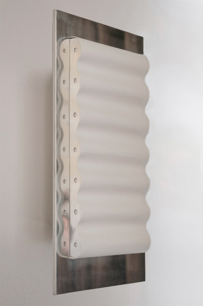 Les appliques Frame Acier Miroir de Violaine d'Harcourt sont fabriquées à la main au Portugal, en acier laqué argenté et en papier.

Dotées d'un design minimaliste et rendant un subtil hommage à l'architecture moderne, les appliques murales Frame sont réalisées avec des matériaux contrastés qui rehaussent le toucher doux d'une vague de papier.