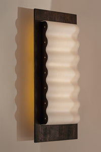 Les appliques Frame Wood de Violaine d'Harcourt sont fabriquées à la main au Portugal avec du bois d'acajou huilé et du papier.

Dotées d'un design minimaliste et rendant un subtil hommage à l'architecture moderne, les appliques murales Frame sont réalisées avec des matériaux contrastés qui rehaussent le toucher doux d'une vague de papier.