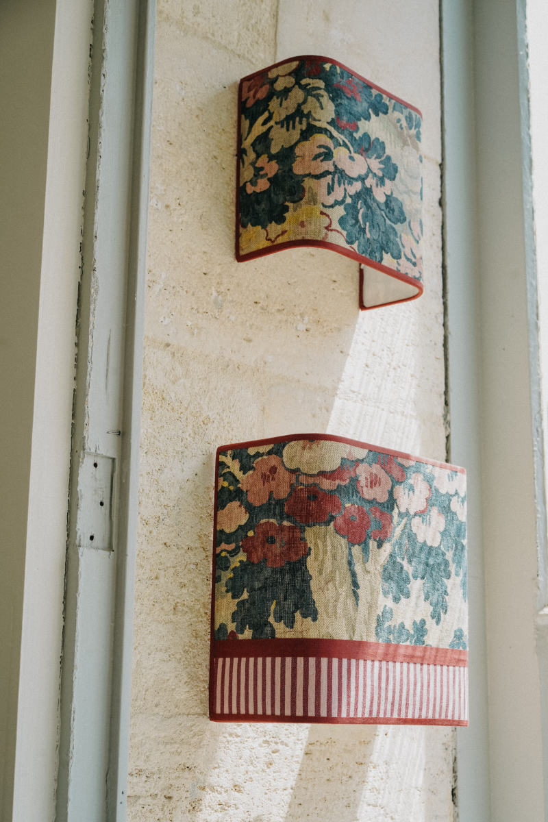 Ajoutez une touche d'élégance florale à votre intérieur avec l'applique murale HARLOW à motifs fleurs. Conçue pour illuminer vos espaces tout en apportant une note de fraîcheur, cette applique est l'accessoire idéal pour toute pièce de la maison.
Elle diffuse une lumière douce et chaleureuse.

Cette applique est le fruit d'une collaboration entre Caroline Andréoni La Maison et My Leone. Elle existe en 2 tailles et en 2 versions différentes : full Harlow et Harlow avec tissu à rayures blanche et rouge.