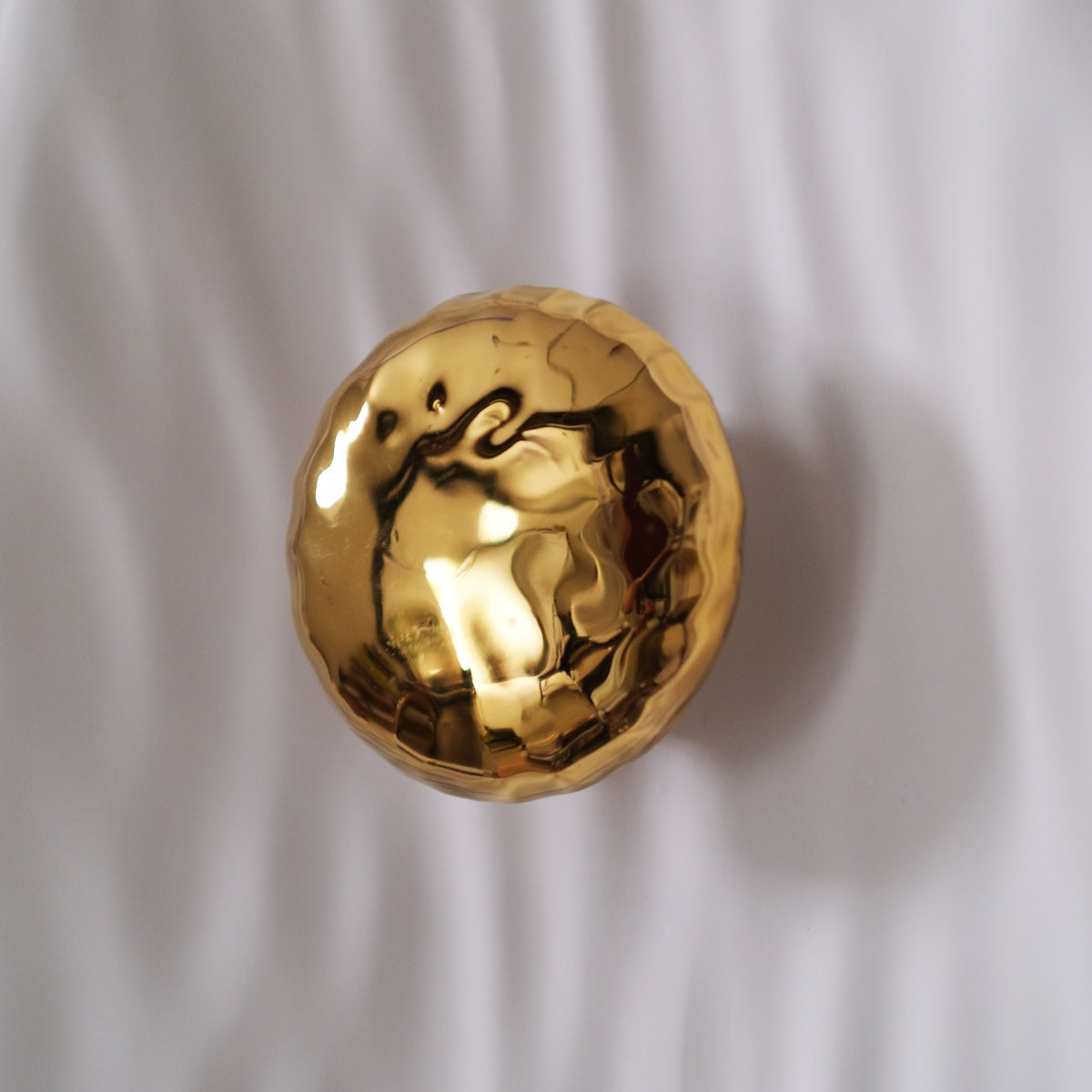 Façonnée à la main, l’applique Vesta associe un disque en faïence émaillée doré 24K, à une structure en plâtre sculpté aux lignes organiques.

Conçue comme une offrande à la lumière, Vesta rend hommage à la déesse du foyer. Elle diffuse une lumière douce et enveloppante, idéale pour instaurer une atmosphère apaisante et sacrée.