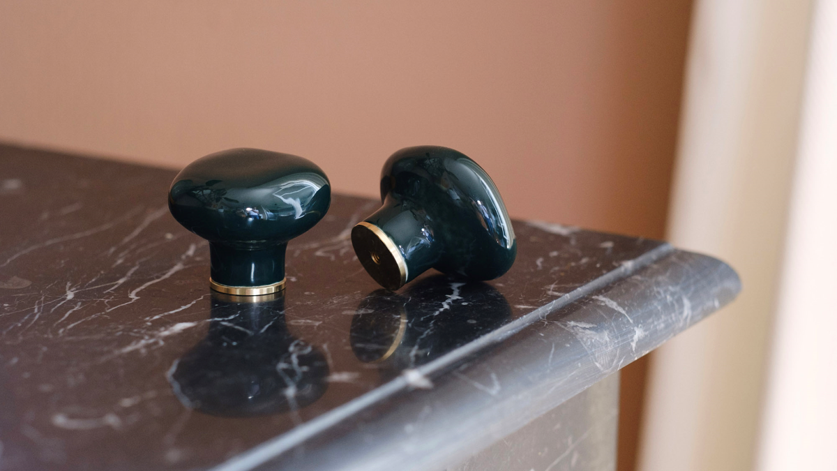 Le bouton de meubles Agate tire son nom de la pierre précieuse éponyme. Les Grecs et les Égyptiens l'utilisaient déjà dans la confection d'objets sacrés. Chaque poignée possède sa propre personnalité, accentuée par les émaux cristallisés ou colorés qui s'harmonisent avec sa forme douce et organique, reflétant la diversité des teintes présentes dans les pierres d'Agate. Son design intemporel et organique évoque la beauté et la simplicité des galets, tandis que sa base est ornée d'une bague en laiton.