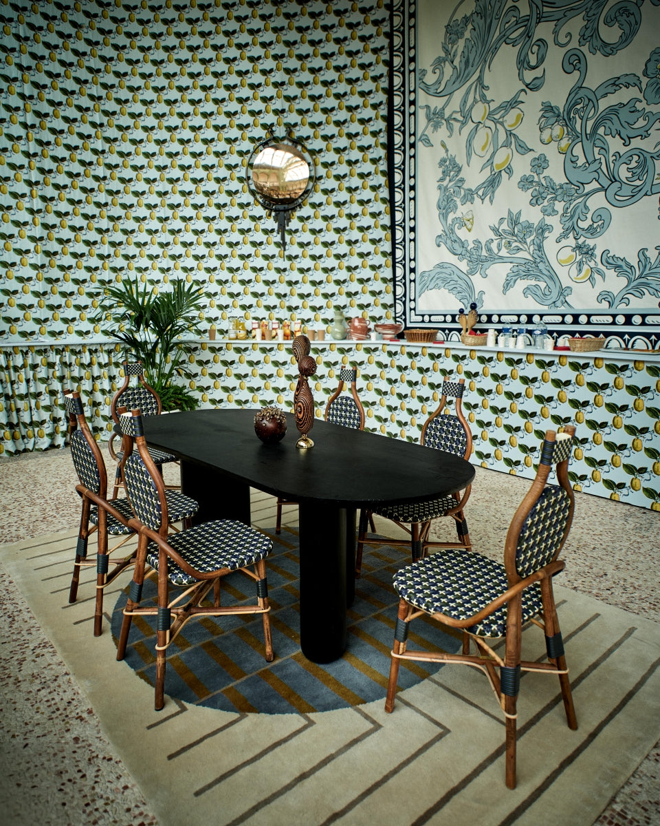 La chaise Odette fait la part belle au rotin. Le Second Empire a vu se développer le métier de rotinier et a été l’âge d’or de ce matériau. Le rotin est une tige de palmier importée des forêts tropicales asiatiques à l’époque coloniale. La chaise de bistro en rotin symbolise à elle seule les terrasses parisiennes et la gaieté de la capitale française. La forme florale et l’utilisation de matières végétales pour le design de la chaise Odette est une référence au catleya.