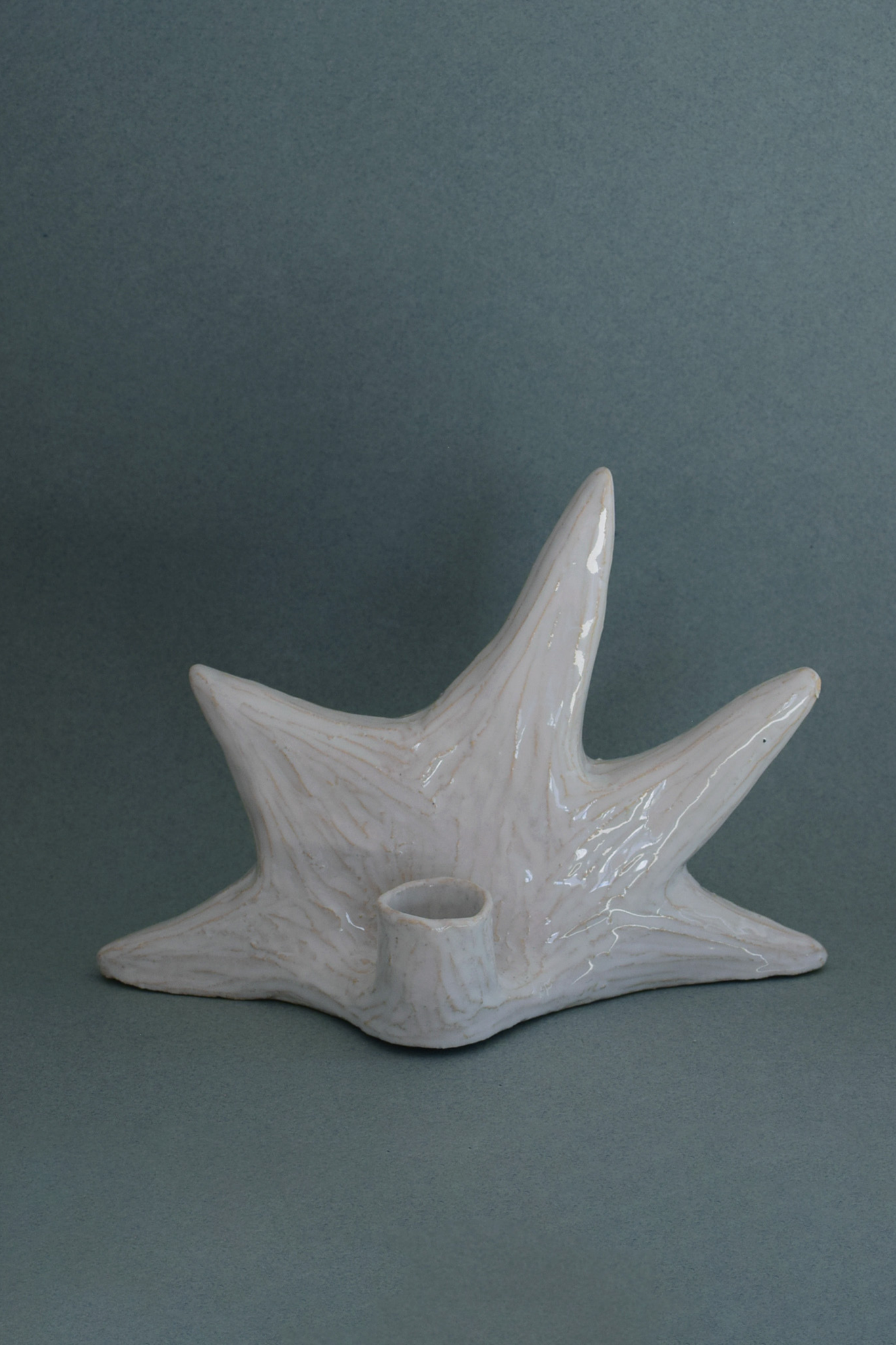 Le Chandelier Étoile, issu de la collection Pierrot, évoque l’univers tendre et mélancolique du célèbre clown rêveur. Son modelage, tout en douceur, rend hommage à la nuit et à ses étoiles en s'inspirant de la célèbre comptine Au Clair de la Lune. Qu’il éclaire une table de chevet ou un coin de salon, Le Chandelier Étoile incarne une poésie discrète. Façonné entièrement à la main, chaque bougeoir présente des irrégularités subtiles qui témoignent d'un geste instinctif.

Pièce unique, fabriquée à la main.