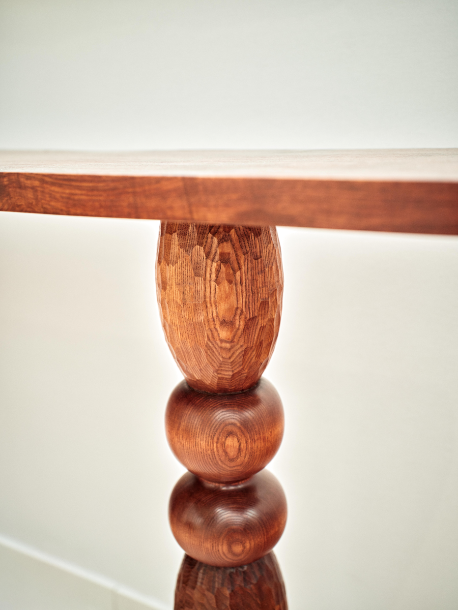 Imaginée en exclusivité pour Caroline Andréoni, la console Volterra explore le dialogue subtil entre équilibre et mouvement. Travaillée comme une sculpture fonctionnelle, elle joue sur l'asymétrie de ses appuis, mêlant force et légèreté dans un même élan.
Le bois, laissé volontairement expressif, révèle sous la main ses veines, ses nœuds et ses nuances, invitant à une lecture tactile de la matière. Chaque détail, du galbe des pieds à la finesse du plateau, célèbre l'imperfection vivante du matériau.