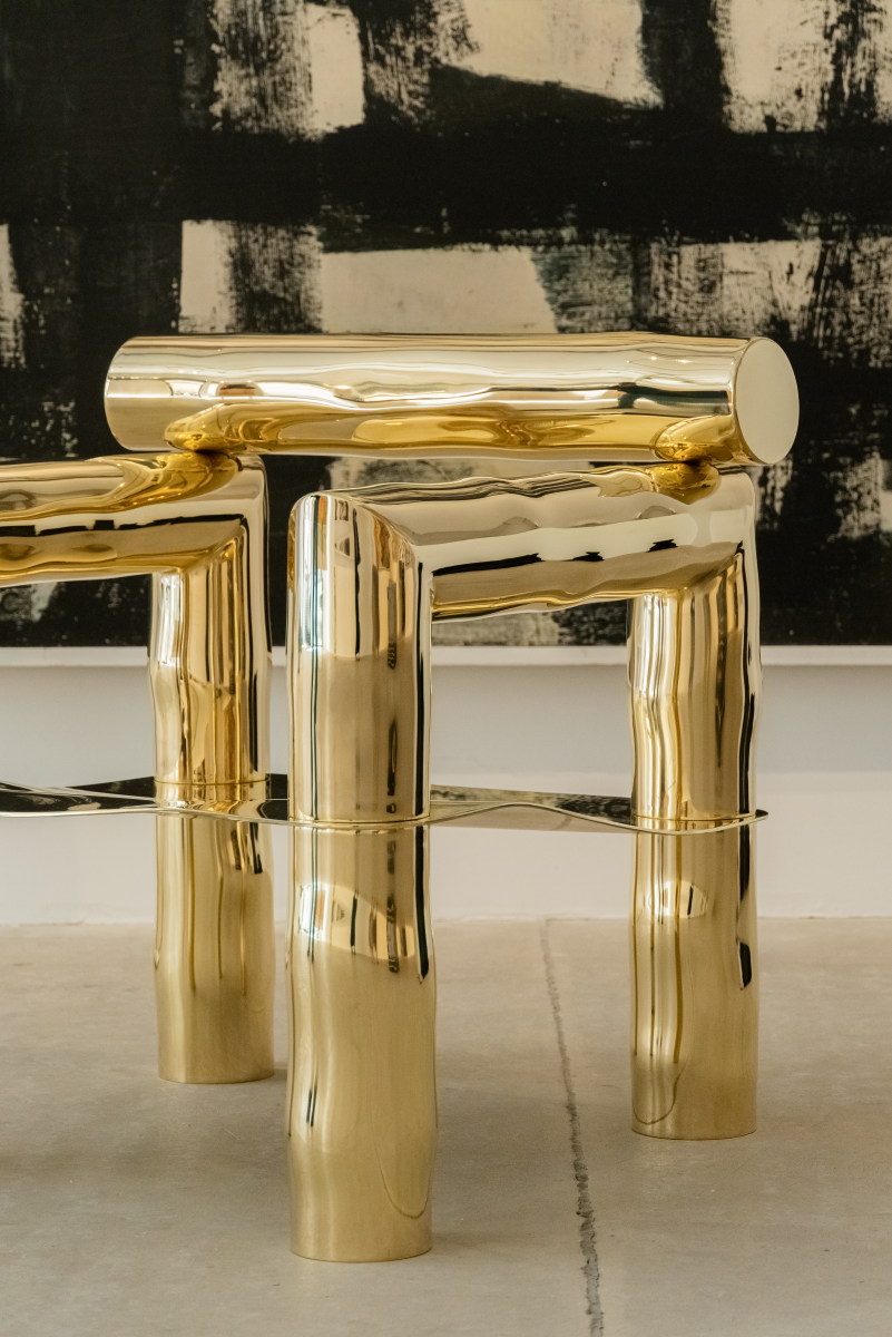Bobi est un fauteuil sculptural en laiton poli miroir, non verni. Composé de tubes de laiton formés manuellement dans un dialogue entre lignes franches et courbes organiques, il associe structure et poésie.

Son assise, une tôle de laiton de 4 mm formée à la main, offre un confort enveloppant grâce à ses ondulations. Son aspect miroir crée une expérience sensorielle unique : l’assise se drape de son environnement, déformant la réalité et fascinant la perception.
