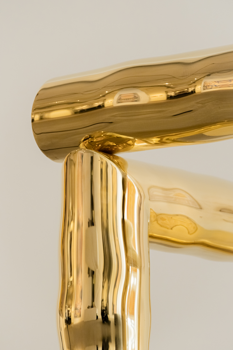 Bobi est un fauteuil sculptural en laiton poli miroir, non verni. Composé de tubes de laiton formés manuellement dans un dialogue entre lignes franches et courbes organiques, il associe structure et poésie.

Son assise, une tôle de laiton de 4 mm formée à la main, offre un confort enveloppant grâce à ses ondulations. Son aspect miroir crée une expérience sensorielle unique : l’assise se drape de son environnement, déformant la réalité et fascinant la perception.