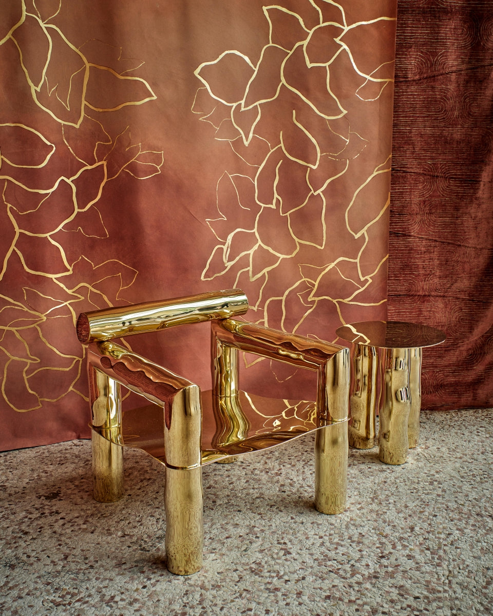 Bobi est un fauteuil sculptural en laiton poli miroir, non verni. Composé de tubes de laiton formés manuellement dans un dialogue entre lignes franches et courbes organiques, il associe structure et poésie.

Son assise, une tôle de laiton de 4 mm formée à la main, offre un confort enveloppant grâce à ses ondulations. Son aspect miroir crée une expérience sensorielle unique : l’assise se drape de son environnement, déformant la réalité et fascinant la perception.