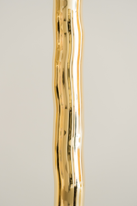 Hélios est un lampadaire sculptural en laiton poli miroir, non verni. Sa source lumineuse, dissimulée, diffuse une lumière douce vers le haut. Entièrement formée, soudée et polie à la main, chaque pièces de cette série sont uniques. Le reflet de sa hauteur dans son socle crée une illusion de mouvement, d’infini, un jeu de perceptions où le vertige s’invite. Hélios transforme l’espace, oscillant entre objet fonctionnel et œuvre sculpturale.