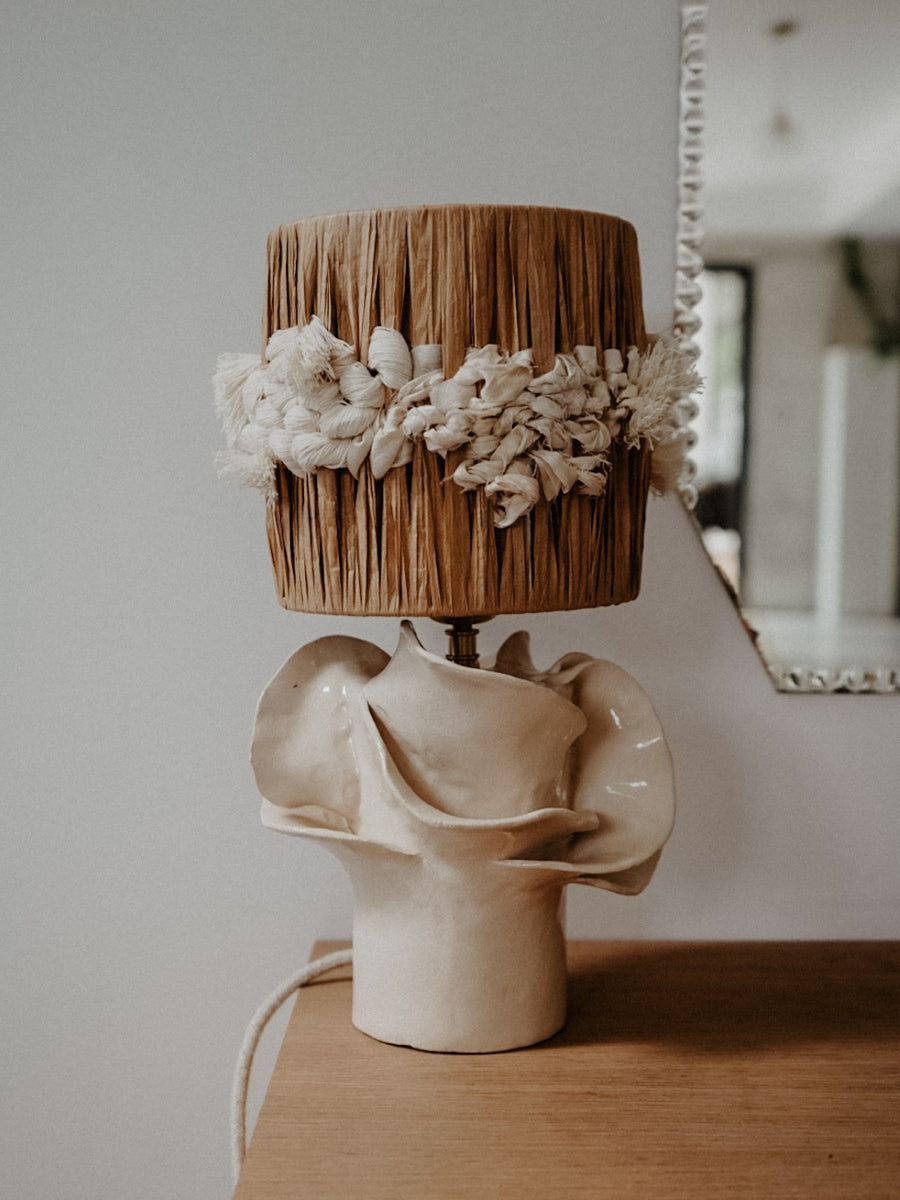 Pour cette lampe, Julie Robert s’est laissé inspirer par les champs de fleurs — surtout des pivoines — qui s’épanouissent chaque printemps sur les hauteurs dominant sa maison du sud de la France. Chaque année, elle observe patiemment la naissance des feuillages, leur croissance silencieuse jusqu’aux dernières récoltes. De cette contemplation rituelle est née l’envie de capturer la grâce éphémère de l’éclosion, de figer dans la lumière les formes mouvantes des pétales.