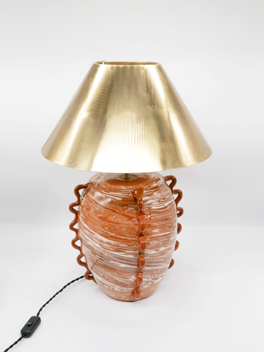 Fruit d’une rencontre entre Datcha et Caroline Andréoni La Maison, la lampe "Kassabah" incarne l’équilibre parfait entre savoir-faire ancestral et design contemporain.

Entièrement façonnée à la main dans les ateliers de potiers marocains, chaque pièce est unique. Le pied en faïence émaillée, réalisé selon la technique des terres mêlées, dévoile un marbré naturel aux nuances terracotta et ivoire. Les anses organiques en relief accentuent son caractère sculptural.