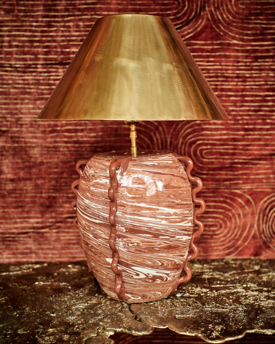 Fruit d’une rencontre entre Datcha et Caroline Andréoni La Maison, la lampe "Kassabah" incarne l’équilibre parfait entre savoir-faire ancestral et design contemporain.

Entièrement façonnée à la main dans les ateliers de potiers marocains, chaque pièce est unique. Le pied en faïence émaillée, réalisé selon la technique des terres mêlées, dévoile un marbré naturel aux nuances terracotta et ivoire. Les anses organiques en relief accentuent son caractère sculptural.