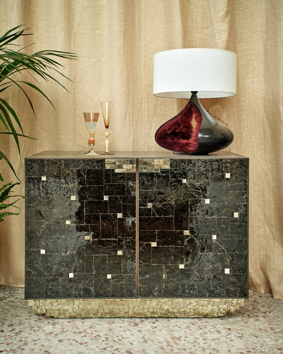 La lampe Bombelle, en bronze patiné noir, propose un volume plus resserré, plus intime. Elle n’impose pas sa présence, elle chuchote. La lumière s’y glisse comme un souffle, subtilement tamisée.

Bombelle, c’est le désir de créer une présence apaisante dans l’espace. Non pas un objet figé, mais un lieu sensoriel, presque un refuge.