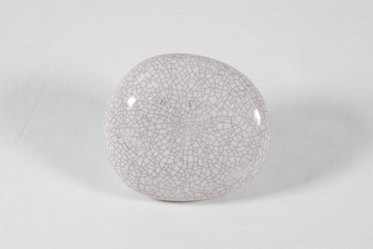 La patère Agate tire son nom de la pierre précieuse éponyme. Chaque patère possède sa propre personnalité, accentuée par les émaux cristallisés ou colorés qui s’harmonisent avec sa forme douce et organique, reflétant la diversité des teintes présentes dans les pierres d’Agate.  Son design intemporel et organique évoque la beauté et la simplicité des galets, tandis que sa délicate base est ornée d’une bague en laiton brossé.