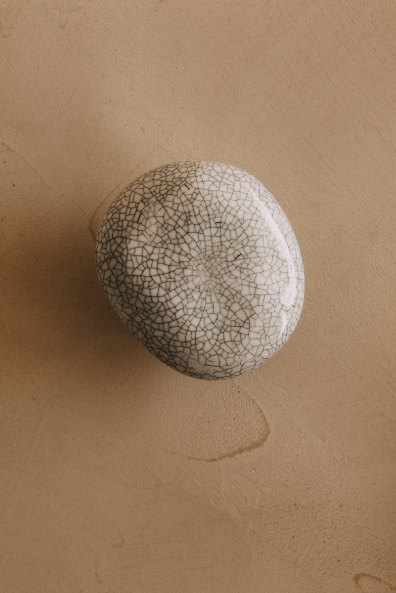 La patère Agate tire son nom de la pierre précieuse éponyme. Chaque patère possède sa propre personnalité, accentuée par les émaux cristallisés ou colorés qui s’harmonisent avec sa forme douce et organique, reflétant la diversité des teintes présentes dans les pierres d’Agate.  Son design intemporel et organique évoque la beauté et la simplicité des galets, tandis que sa délicate base est ornée d’une bague en laiton brossé.