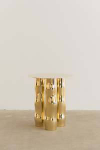 Mimo est une table d’appoint en laiton poli miroir, non verni. Sa structure repose sur une intention formelle simple : trois pieds et un plateau. Ses pieds, formés de manière organique, contrastent avec la ligne fine et délicate de son plateau.

La surface polie capte la lumière et reflète l’environnement, révélant l’élégance contenue dans la simplicité. Le laiton, travaillé à la main, invite à une expérience sensorielle où la matière et l’espace entrent en conversation.