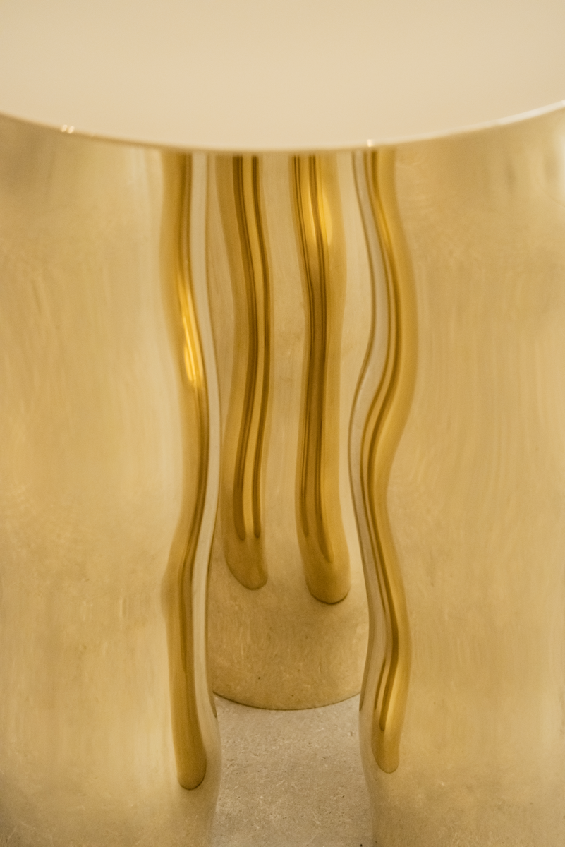 Mimo est une table d’appoint en laiton poli miroir, non verni. Sa structure repose sur une intention formelle simple : trois pieds et un plateau. Ses pieds, formés de manière organique, contrastent avec la ligne fine et délicate de son plateau.

La surface polie capte la lumière et reflète l’environnement, révélant l’élégance contenue dans la simplicité. Le laiton, travaillé à la main, invite à une expérience sensorielle où la matière et l’espace entrent en conversation.