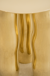 Mimo est une table d’appoint en laiton poli miroir, non verni. Sa structure repose sur une intention formelle simple : trois pieds et un plateau. Ses pieds, formés de manière organique, contrastent avec la ligne fine et délicate de son plateau.

La surface polie capte la lumière et reflète l’environnement, révélant l’élégance contenue dans la simplicité. Le laiton, travaillé à la main, invite à une expérience sensorielle où la matière et l’espace entrent en conversation.